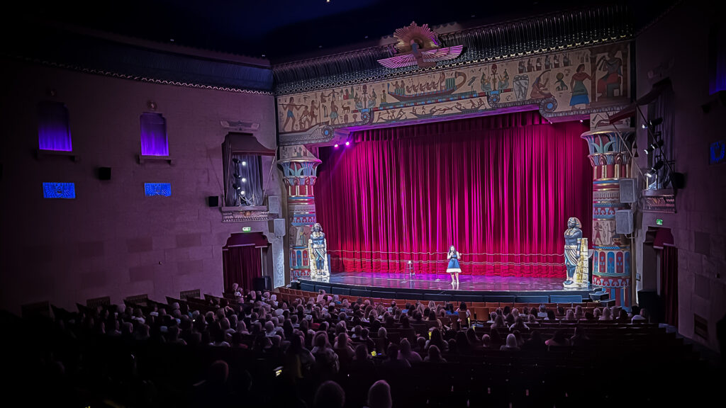 Stacy Pederson on stage delivering an engaging keynote speech to a large crowd